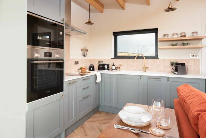 Kitchen equipped with an oven, hob, microwave, kettle and cooking utensils