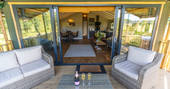 Enjoy a chilled glass sat outside on the decking of your safari lodge at Bird Holme Glamping in Nottinghamshire