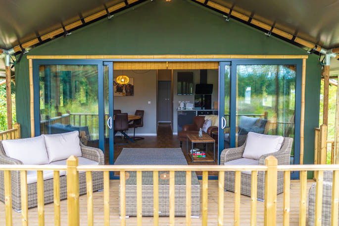 Pop open the prosecco and enjoy a chilled glass sat outside on the decking of your safari lodge at Bird Holme Glamping in Nottinghamshire
