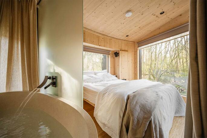 Freestanding bath tub next to the bed