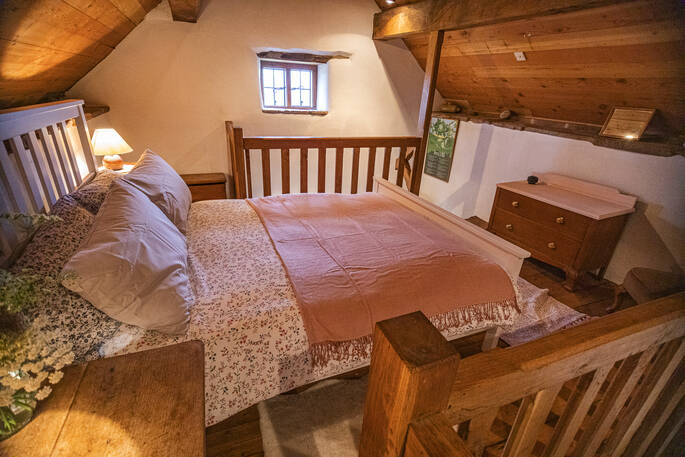 Double bed on mezzanine level inside Damson Cottage in Shropshire 