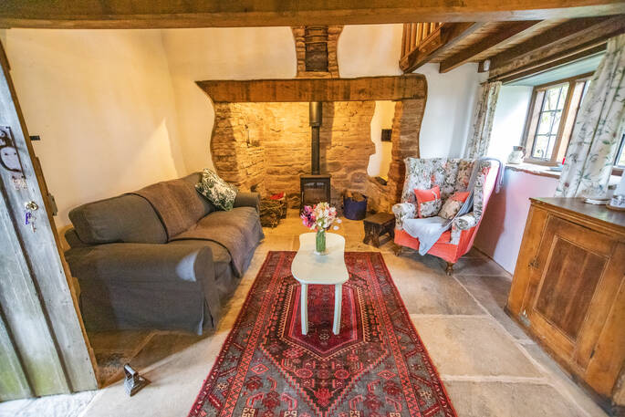 Light the wood-burner and sit in the living room area inside of Damson Cottage in Shropshire 