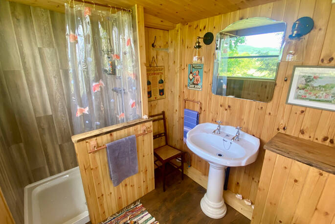 Private shack with a shower, sink and flushing toilet