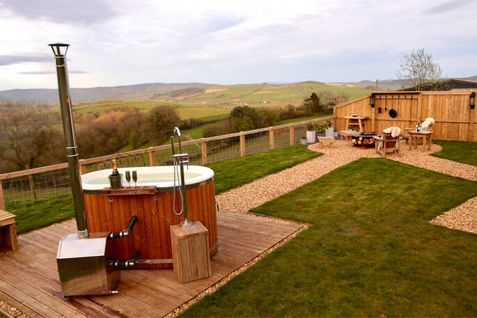 Oak Hut at Shropshire Shepherds Huts garden with a fire pit area and hot tub