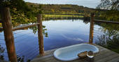 Outdoor bath tub with scenic view to the pond