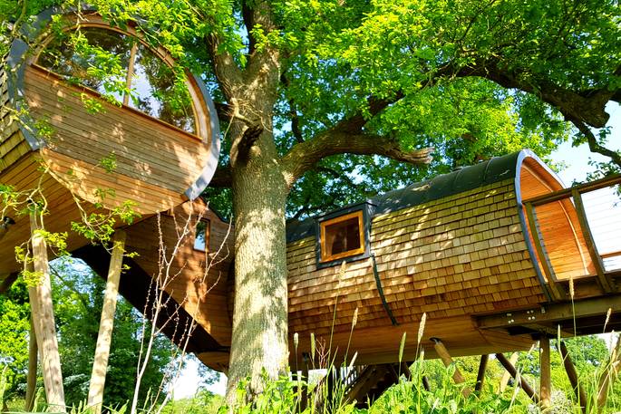 The magnificent Cheriton Treehouse in Somerset, surrounded by green trees