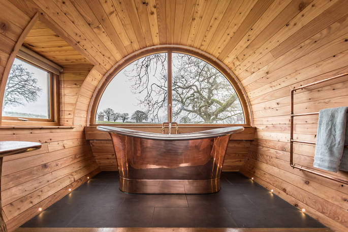 Take an indulgent bubble bath in the giant copper bath for two with countryside views from your elevated treetop perch