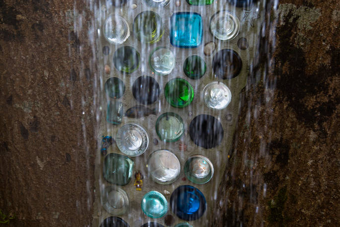 Gin bottle wall in the shower at Deers Leap Yurt, Somerset