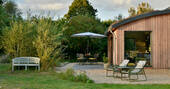 Garden is spacious with outdoor dining, sun loungers and a bench looking out the large field