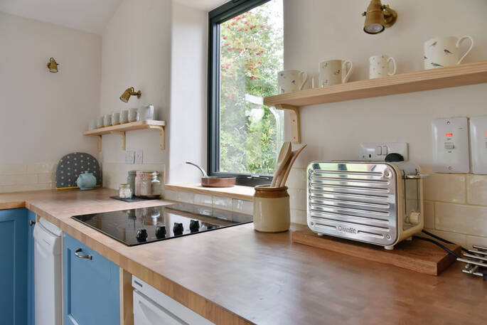 Kitchen equipped with an induction hob, oven, toaster, kettle and a fridge-freezer