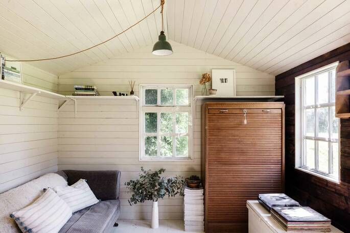 Inside the summerhouse has a sofa, books and plenty of space to relax