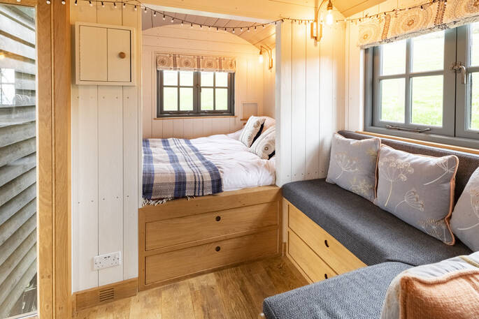 Relax in the cosy double bed inside Tilbury Herdwick shepherd's hut in Somerset