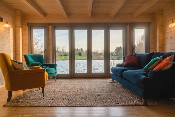 Discovery Lodge cabin living room with view to the lake, Blyth Rise Stays, Laxfield, Suffolk