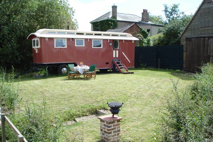 Exterior of Maroon Fairground Wagon with outdoor seating at Coppins Farm in Suffolk