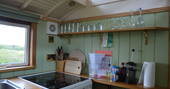 Fully equipped kitchen inside Maroon Fairground Wagon at Coppins Farm in Suffolk