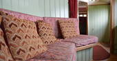Seating area inside Maroon Fairground Wagon at Coppins Farm in Suffolk