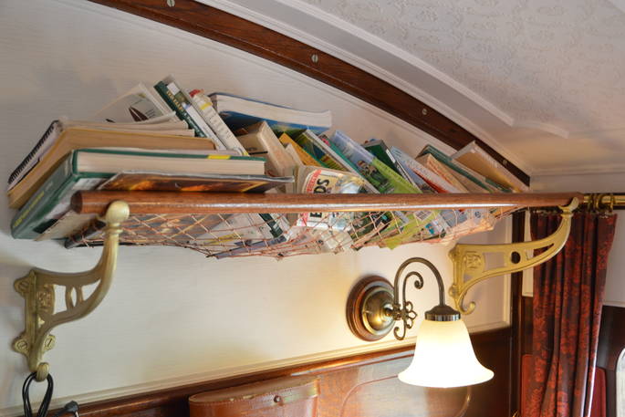Books and decor inside The Victorian Railway Carriage at Coppins Farm in Suffolk
