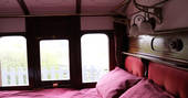 Double bed inside The Victorian Railway Carriage at Coppins Farm in Suffolk