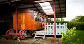 Exterior of The Victorian Railway Carriage with outdoor seating at Coppins Farm in Suffolk