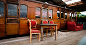 Exterior of The Victorian Railway Carriage with outdoor seating at Coppins Farm in Suffolk