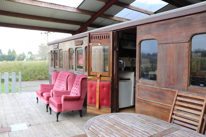 Exterior of The Victorian Railway Carriage with outdoor seating at Coppins Farm in Suffolk