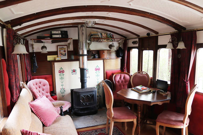 Light the wood-burner and sit inside The Victorian Railway Carriage at Coppins Farm in Suffolk