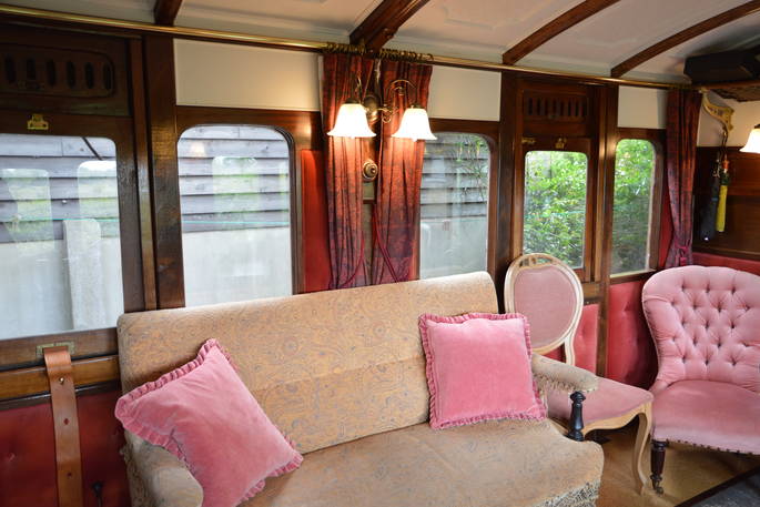 Sit by the wood-burner and relax inside The Victorian Railway Carriage at Coppins Farm in Suffolk