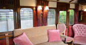 Sit by the wood-burner and relax inside The Victorian Railway Carriage at Coppins Farm in Suffolk