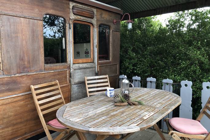 Sit under shelter and dine al fresco outside The Victorian Railway Carriage at Coppins Farm in Suffolk