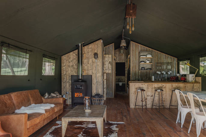 Interior of The Cowshed with wood-burner and fully equipped kitchen at The Lost Garden Retreat in Suffolk