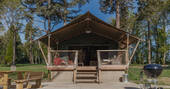The Cow Shed safari tent with hot tub and BBQ outside at The Lost Garden Retreat in Suffolk