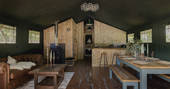 Interior of The Fisherman's Hideaway with wood-burner and fully equipped kitchen at The Lost Garden Retreat in Suffolk