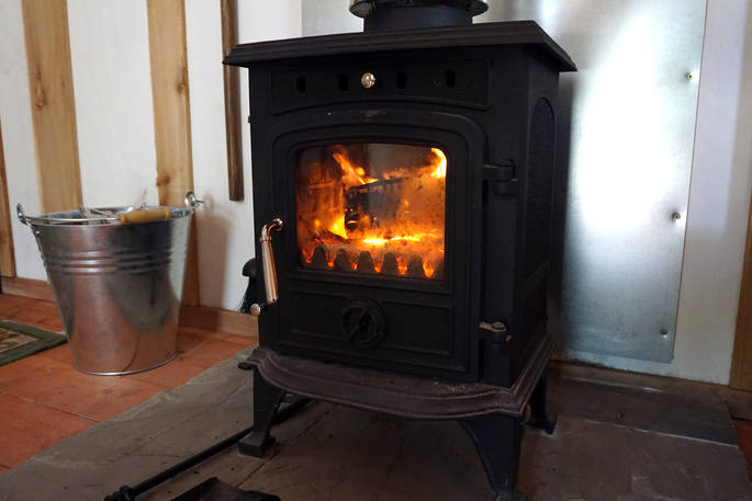 Warm yourself by the wood-burner in Anderida Cabin at Forest Garden in Sussex