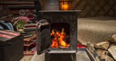 Light up the cosy log burner inside Kushti Yurt at Forest Garden in Sussex