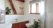 Second bathroom with a bath, shower and flushing toilet