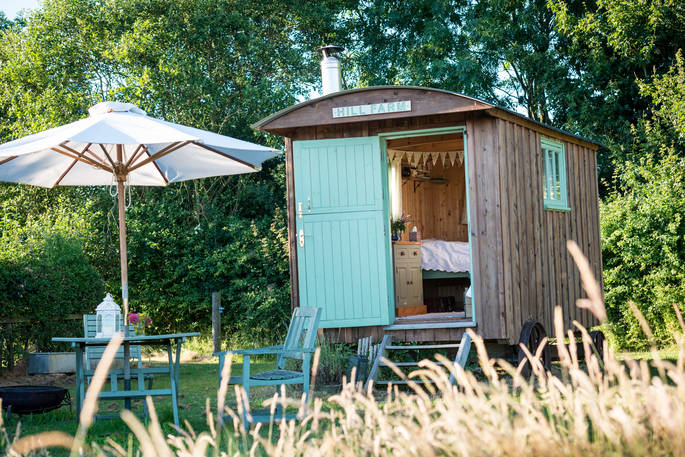 Dine al fresco on the table and chairs outside Jesters Shepherd's Hut at Hill Farm in Warwickshire