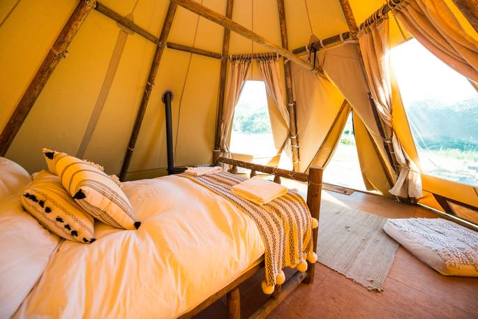Interior of Slinket with one comfortable double bed at Hill Farm Glamping