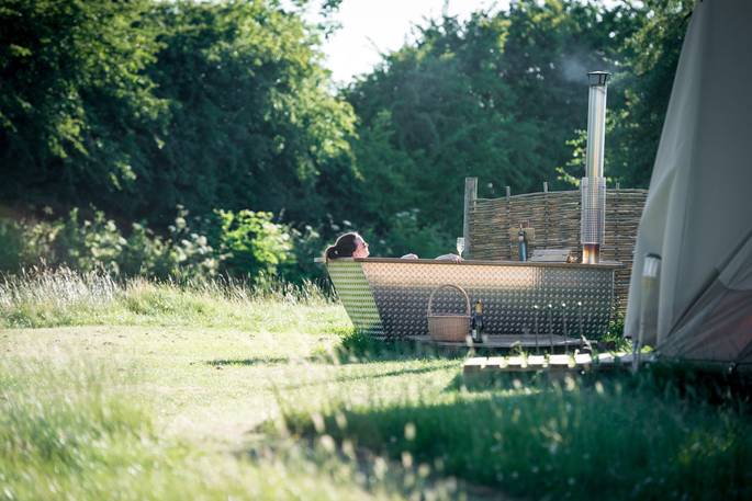 Relax and soak in the hot tub outside Slinket at Hill Farm Glamping in Warwickshire 