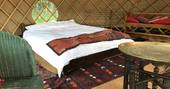 The double bed in the yurt at Hope House Farm in Worcestershire