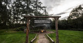 Wooden sign for North Star Club leading to outdoor firepit area