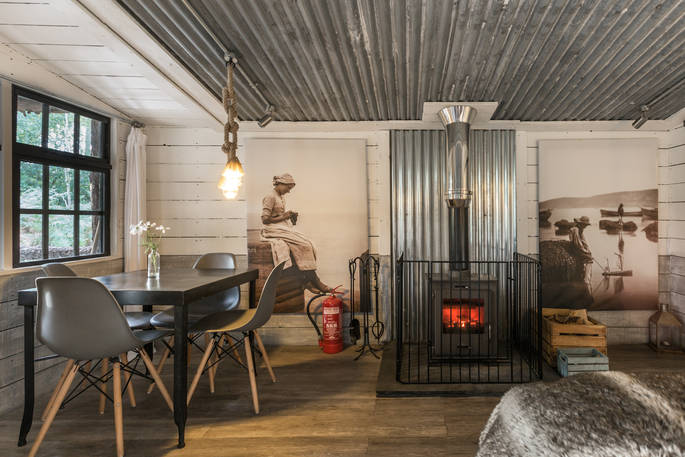 Cosy living area at Whitby cabin, with log burner and table and chairs