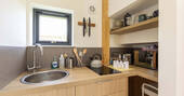 Kitchen equipped with a double induction hob, kettle, cooking equipment, small fridge and sink