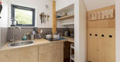 Kitchen equipped with a double induction hob, sink, kettle and cooking utensils