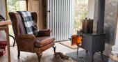 Sit by the wood-burner inside The Bothy Project at Inshriach House in Highland 