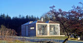 Burnhead Bothies cabin exterior in the sunshine with suntrap terrace and outside seating