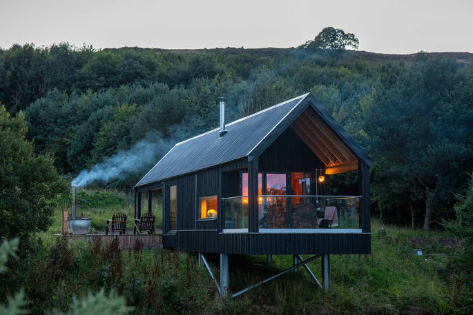 Bothan Dubh cabin at night with smoke from hot tub, Perthshire, Perth & Kinross, Scotland