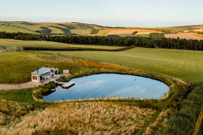 Drone shot of cabin and pond