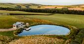 Drone shot of cabin and pond