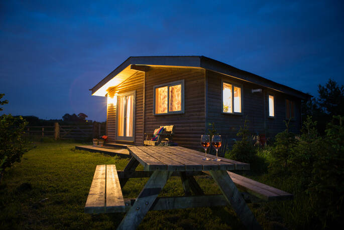 Bwncath cabin at Ty Cerrig, lit up at dusk
