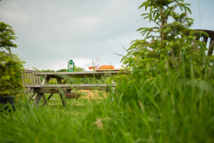 Glasses of rosé wine on the outdoor dining table at Gwdihw shepherd's hut, Ty Cerrig